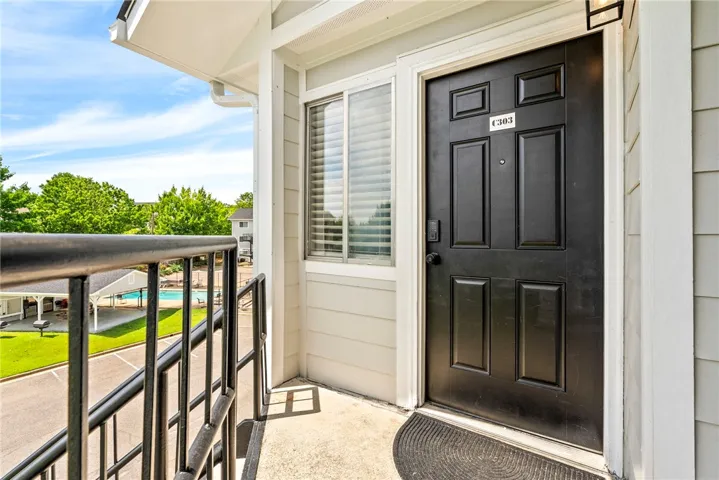 A private entry overlooks the inviting community pool, offering a refreshing view.