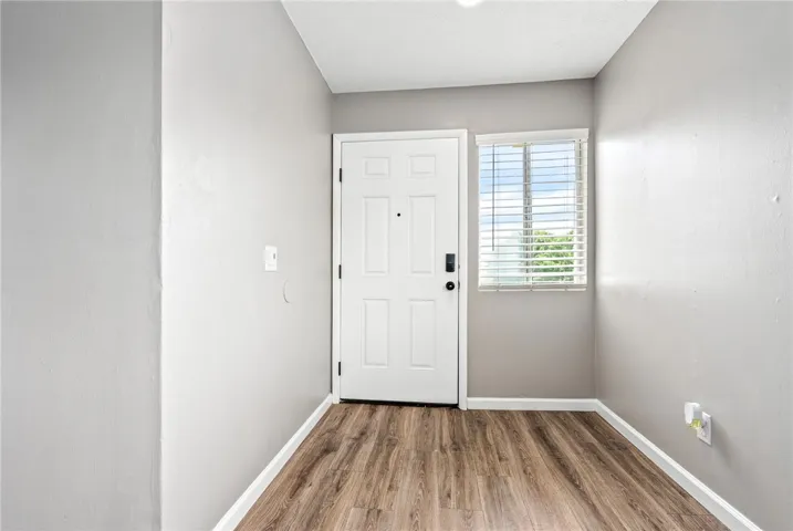 A well-lit entry with rich wood flooring welcomes you home.