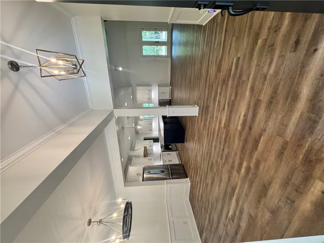 An open floorplan with durable flooring connects a modern kitchen to a welcoming entry.