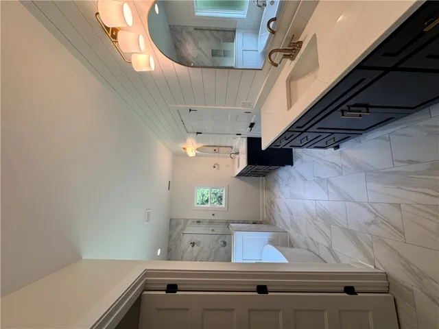 Luxurious tile flooring and a dual vanity with elegant fixtures define this serene bathing space.
