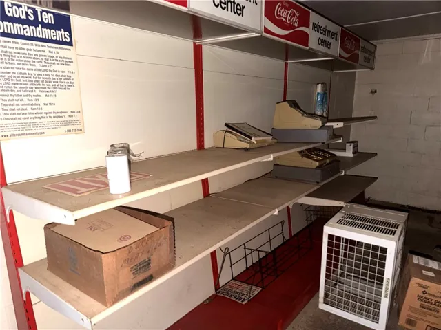 Functional shelving units and vintage cash registers equip this commercial space for business operations.