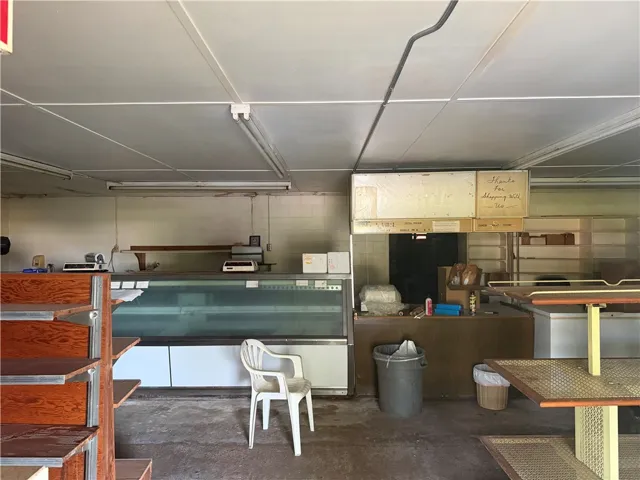 A commercial space ready for revitalization, featuring expansive counter areas and shelving.