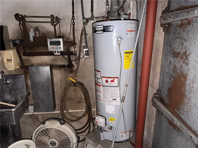 Essential utilities in this practical space, featuring a durable water heater and functional sink.