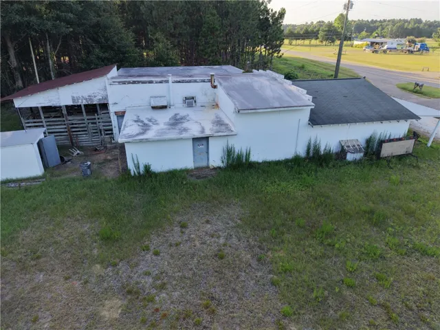 A secluded commercial property offers versatile space with direct road access and natural tree-lined privacy.