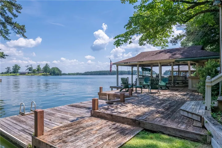 A spacious wood dock and covered patio beckon you to enjoy peaceful lakefront living.