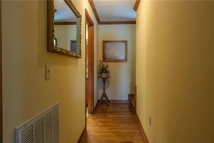 A warm-toned hallway with hardwood floors and rich wood trim welcomes you.