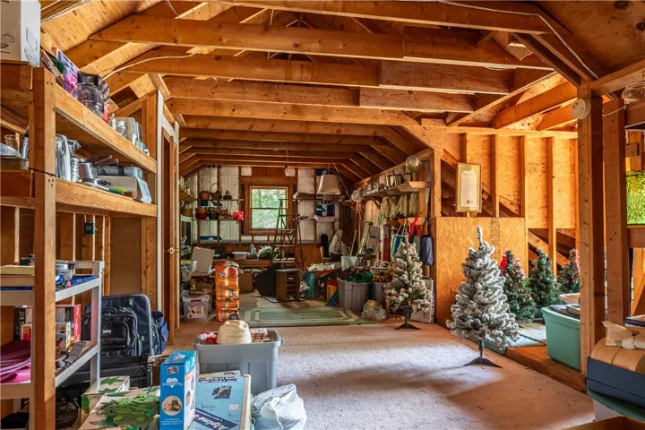 An adaptable attic space featuring exposed wooden beams and ample storage.