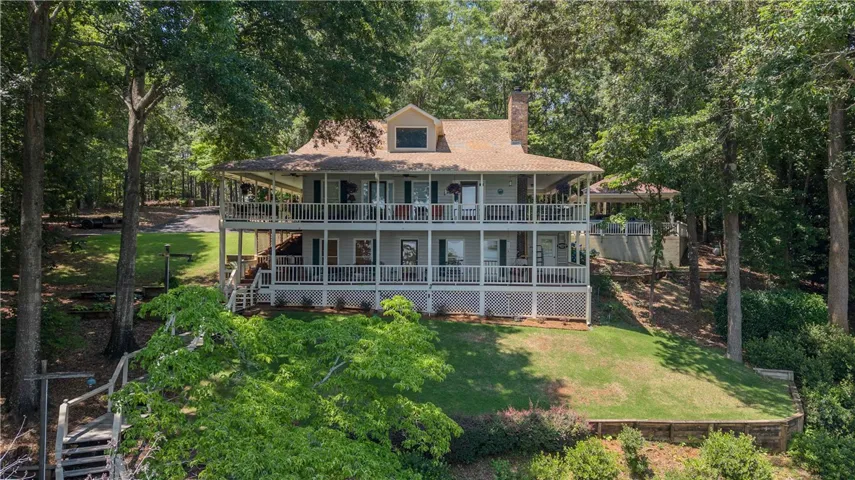 Two levels of inviting wrap-around porches define this charming lakeside retreat amidst mature trees.