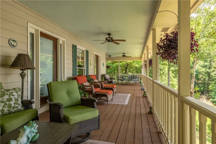 A deep, wrap-around porch extends a peaceful outdoor living space, ideal for relaxation and savoring nature's tranquility.