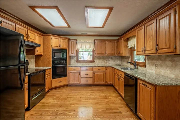 A well-equipped kitchen showcasing rich wood cabinetry and granite countertops.