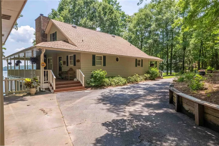 A charming lakefront residence featuring a spacious covered porch with captivating water views.