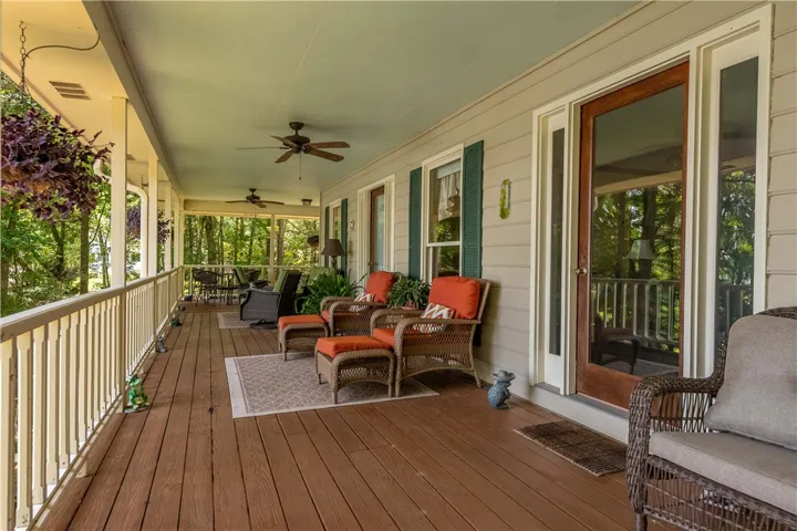 A spacious covered porch invites relaxation, offering ample room for outdoor living amidst lush greenery.