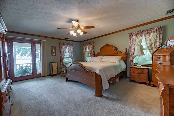 Comfortable bedroom with soft carpeting and private balcony overlooking tranquil waters.
