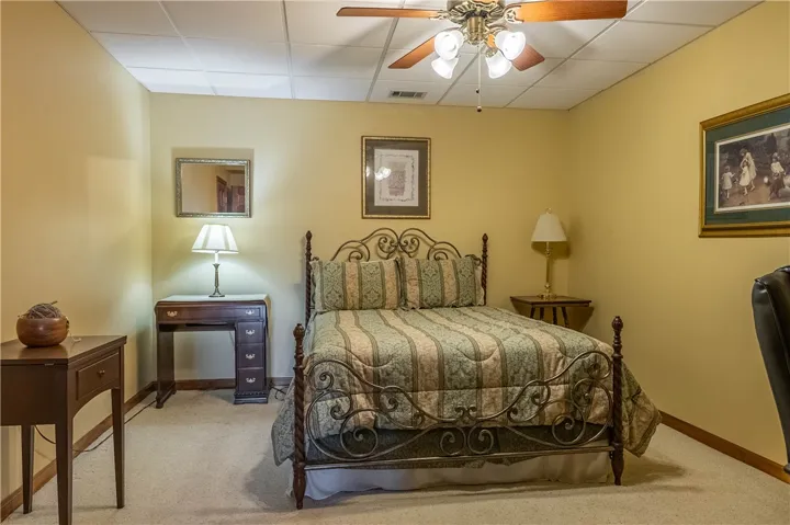 A restful chamber awaits, complete with a classic metal bed frame and soft, muted decor.