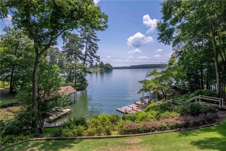 A tranquil lakeside retreat with multiple docks nestled amidst lush greenery and mature trees.