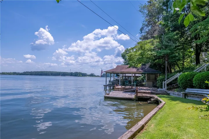 A tranquil lakefront property boasts a private covered boat dock, perfect for waterfront recreation.
