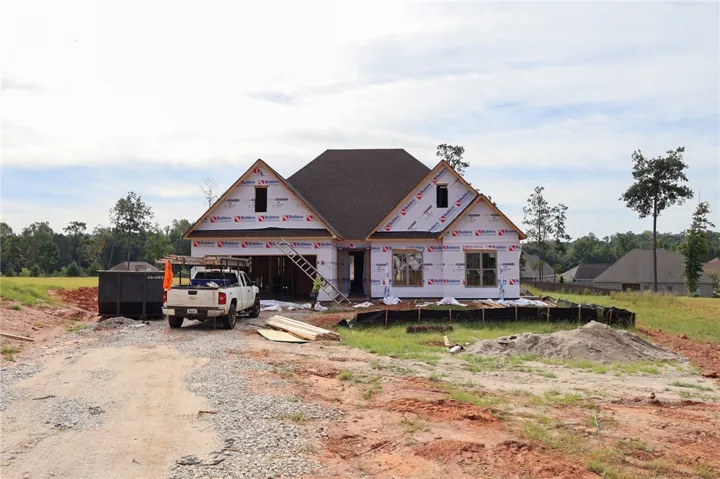 Progress continues on this new construction home showcasing prominent gables and a multi-level roofline.