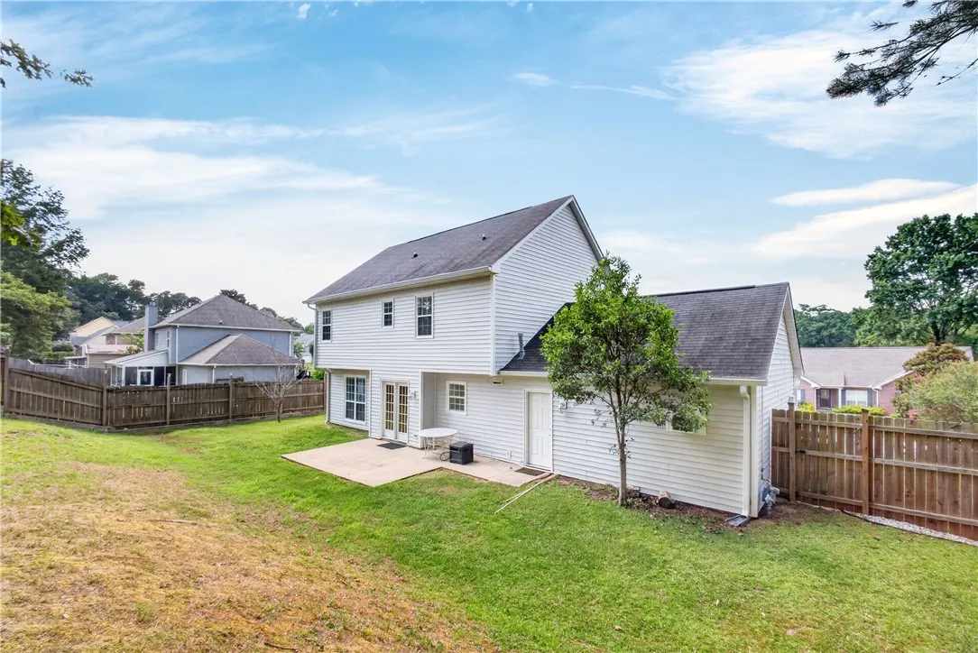 A spacious backyard with a generous patio offers a private outdoor retreat.