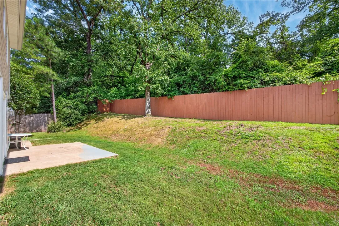 A well-maintained lawn offers ample space for outdoor enjoyment, bordered by a private fence.