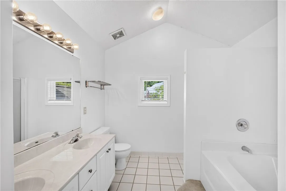 A pristine bath offers dual vanities and a relaxing soaking tub.
