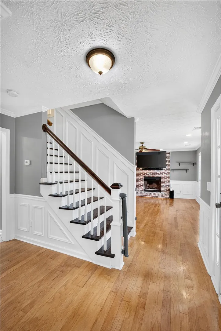 A striking staircase with dark wood treads and white risers anchors a light-filled entryway.