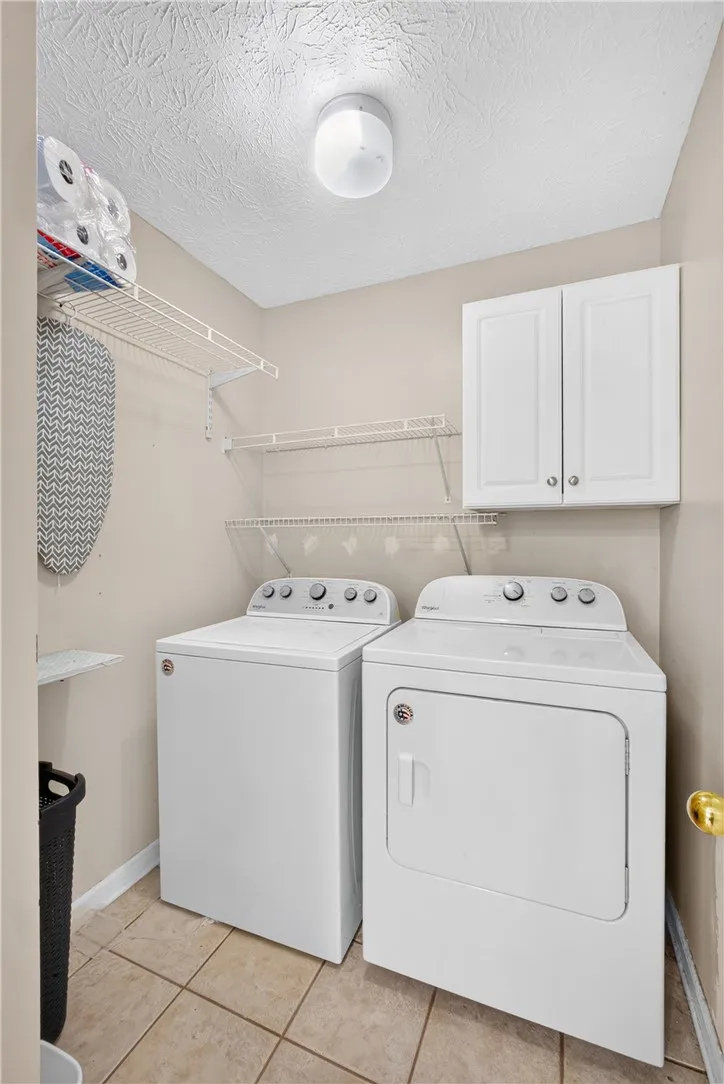 Functional laundry space featuring convenient shelving and cabinetry for organization.