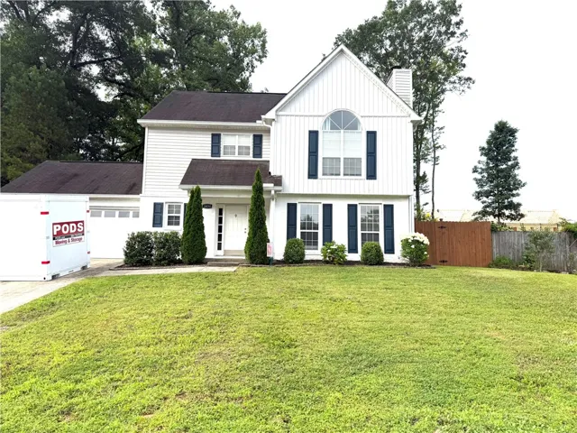 A classic facade with contrasting shutters and manicured shrubs offers charming curb appeal.