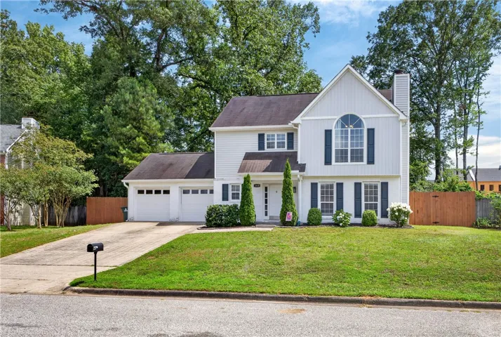 A classic two-story residence with a well-maintained lawn and private fencing.