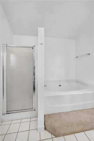 A well-appointed bath offers a sleek shower enclosure and a built-in soaking tub for ultimate relaxation.