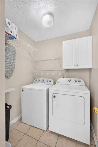 Functional laundry space featuring convenient shelving and cabinetry for organization.