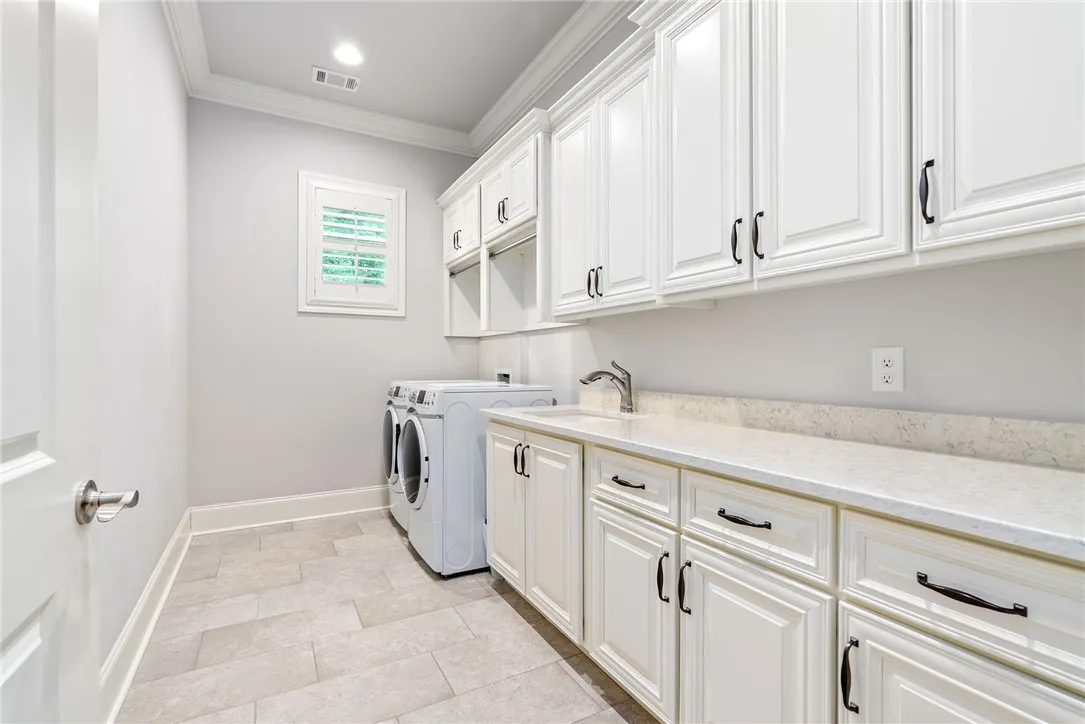 Outfitted with extensive cabinetry, the spacious laundry room offers exceptional storage for household essentials.
