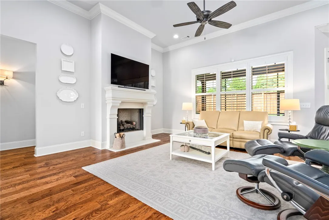 Filled with natural light, the great room features a triple window, gas fireplace, gleaming hardwood floors, and clean architectural lines.