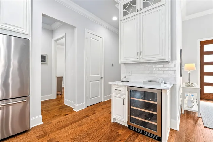 Adjacent to the walk-in pantry, the dedicated beverage bar features a wine cooler and custom cabinetry for coffee and wine service.