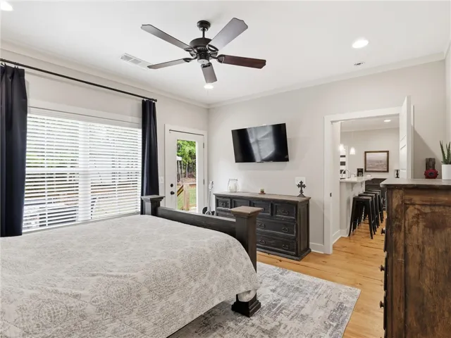 Hardwood flooring extends throughout this naturally illuminated bedroom with a private exterior door to the deck.
