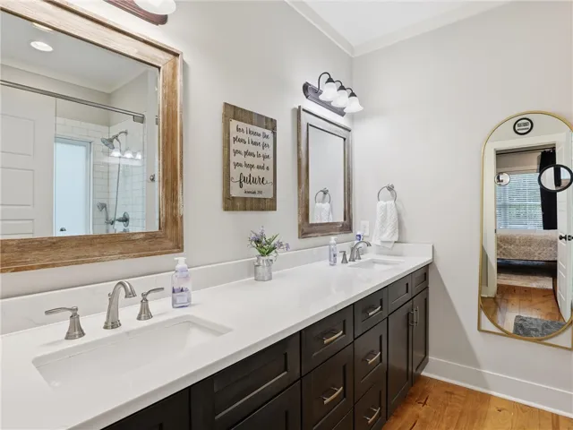 Double vanities with quartz countertops offer ample space for daily routines in this well-appointed bath.