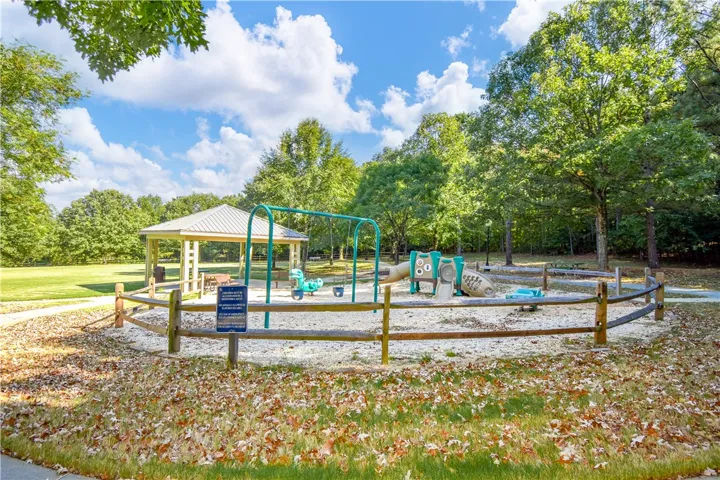 A community playground awaits with swings, slides, and a shaded picnic area.