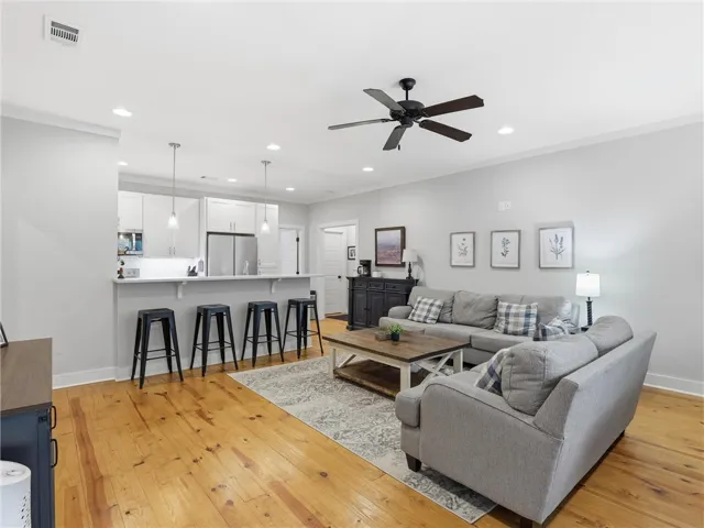 Blonde hardwood floors complement a well-lit living area and an open-concept kitchen.