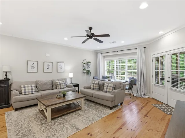 Natural light illuminates this inviting living area, featuring rich hardwood flooring and a charming dining nook.