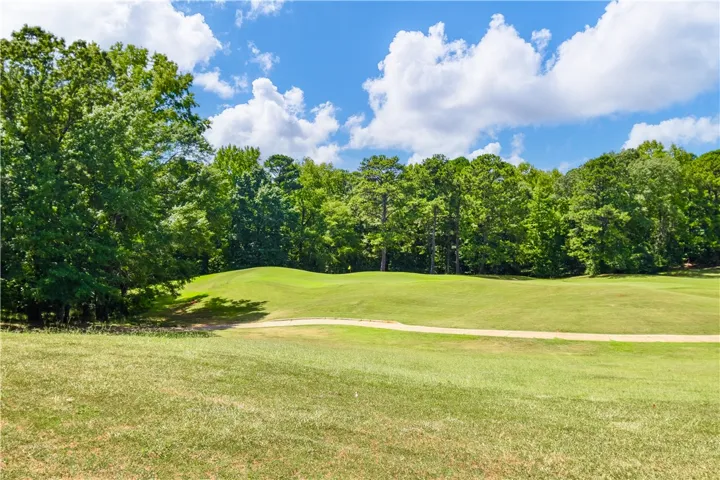 Green fairways invite golfers, with dense tree lines creating a peaceful and private course setting.