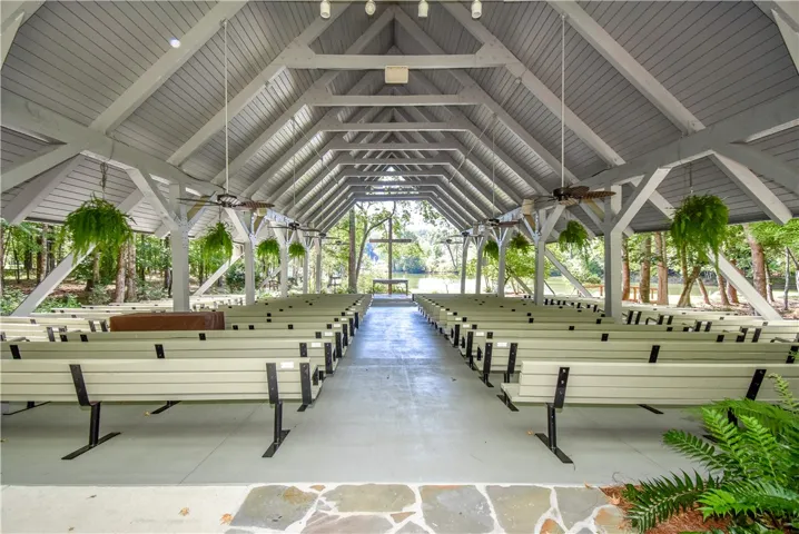 An open-air venue with vaulted ceilings and lake views creates a peaceful gathering space.