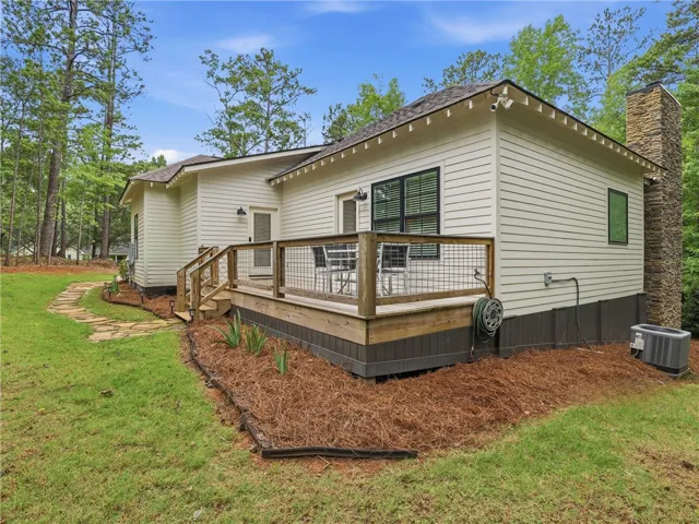 An inviting rear deck and stone pathway complement this home's tranquil, wooded surroundings.