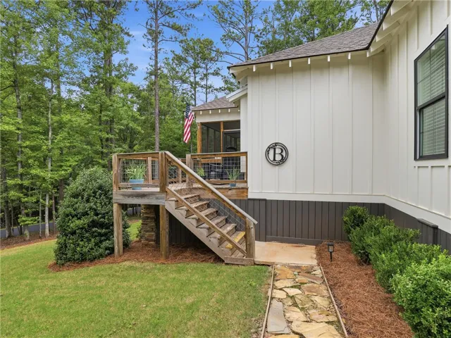 A stone pathway leads to a wooden deck, perfectly complementing the rustic exterior of this home.