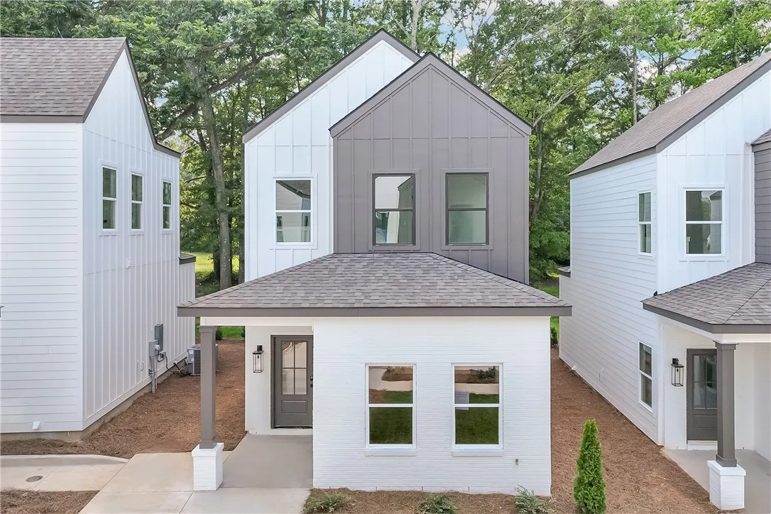 A modern two-story home with clean lines and contrasting gray and white siding.