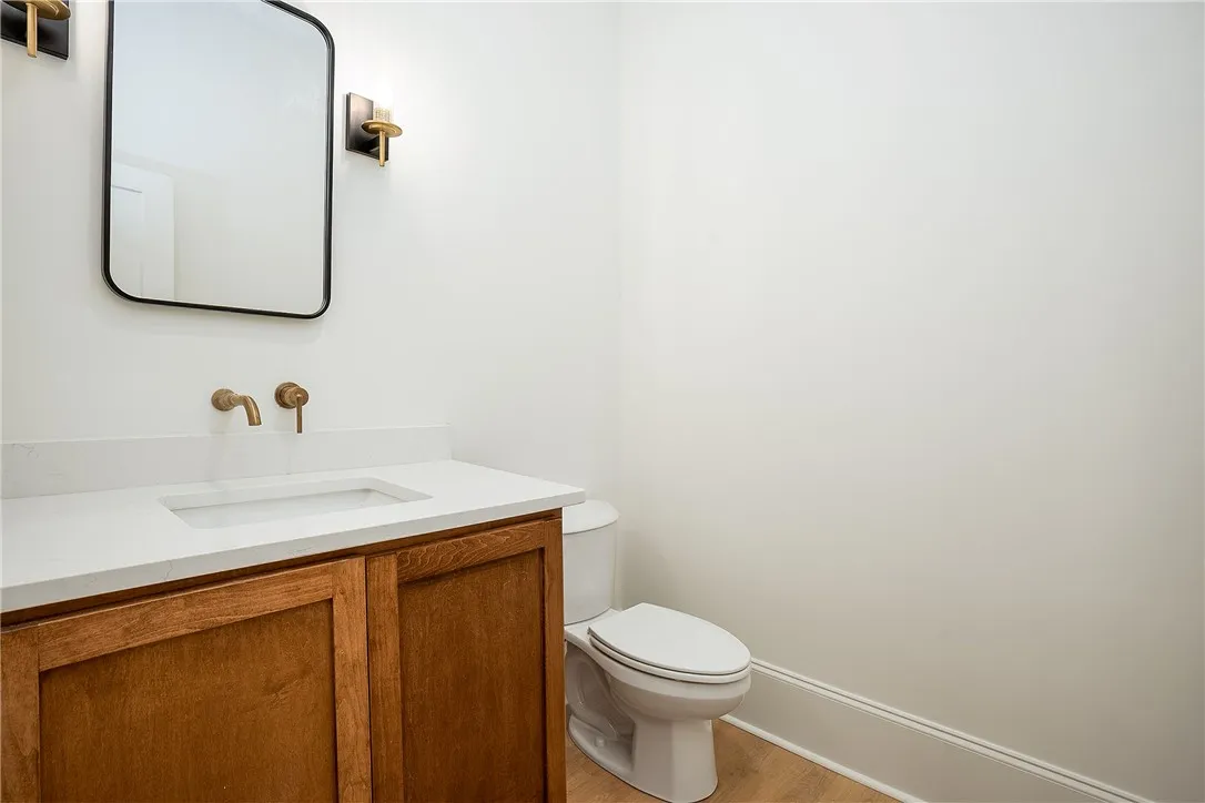 A well-appointed half bath features a stylish vanity with a wall-mounted faucet and elegant lighting.