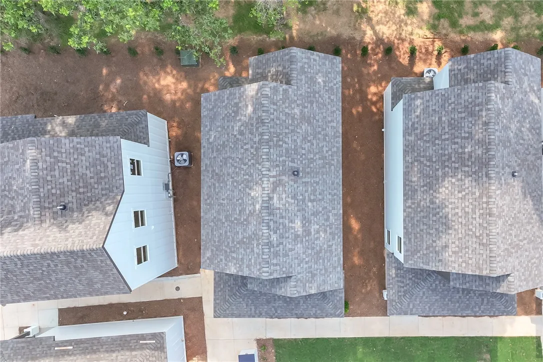 An aerial perspective showcases a collection of new homes with shingle roofs and simple landscaping.