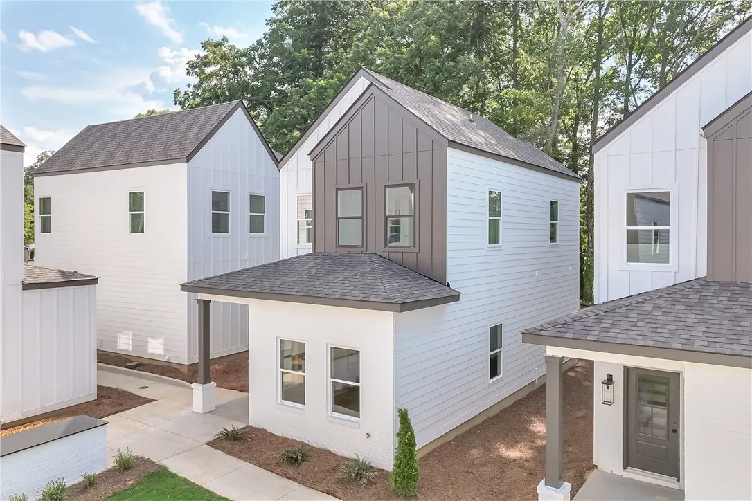 Modern townhomes with striking vertical siding and clean lines, nestled amidst mature trees.