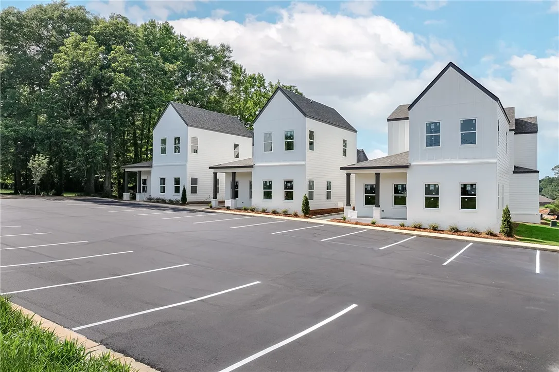 These modern white homes are enhanced by a spacious asphalt parking area.