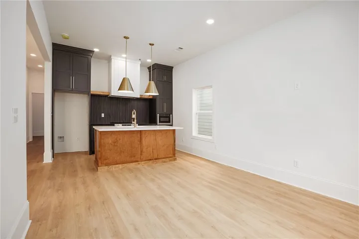 An open-concept design connects the kitchen's island and pendant lighting with the spacious living area.