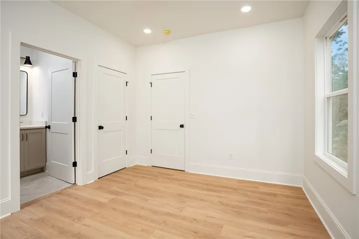 A well-proportioned interior space offers warm wood-look flooring and clean white walls, creating an inviting canvas.