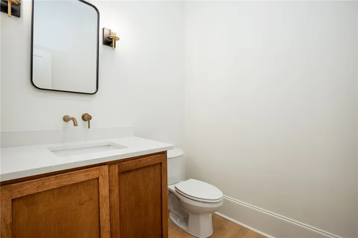 A well-appointed half bath features a stylish vanity with a wall-mounted faucet and elegant lighting.